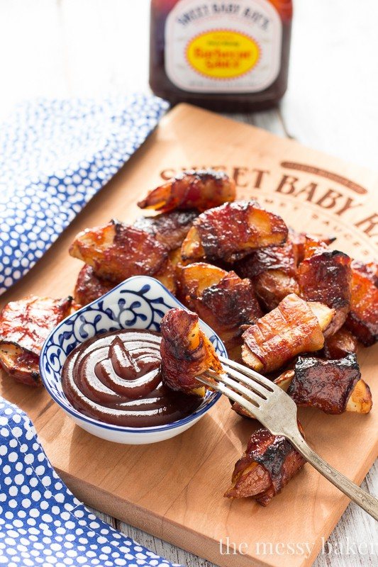 These crispy potato wedges wrapped in smoky bacon and glazed with barbecue sauce make the perfect appetizer for football, the holidays, and parties. | www.themessybakerblog.com