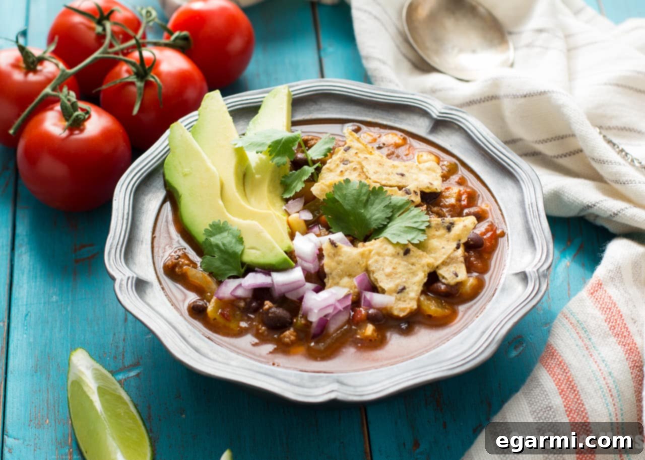 Overhead view of Chorizo Taco Soup in a bowl with toppings