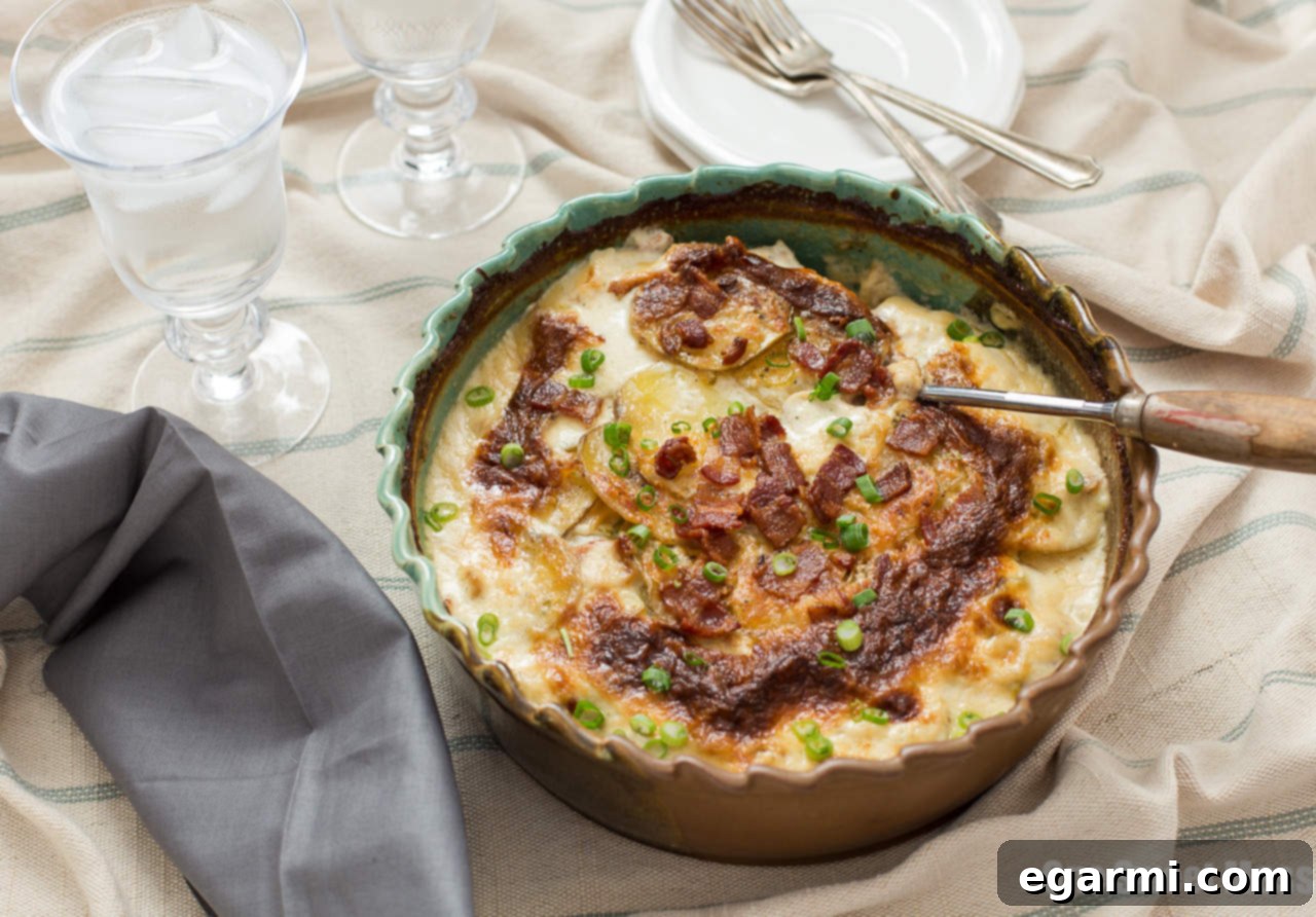Layers of creamy Roasted Garlic, Bacon & Chive Au Gratin Potatoes baking to perfection