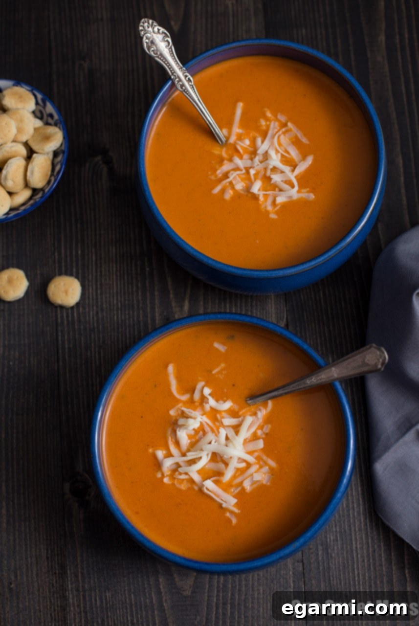 Overhead shot of Roasted Red Pepper Smoked Gouda Soup with a spoon, ready to be enjoyed.