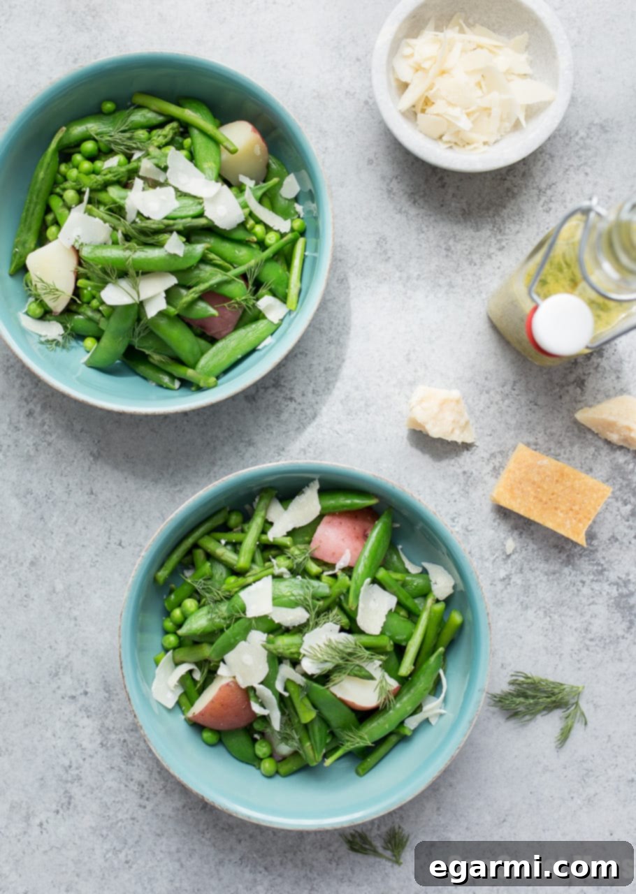 Close-up of fresh spring vegetables including snap peas, English peas, and asparagus, ready for a healthy salad.