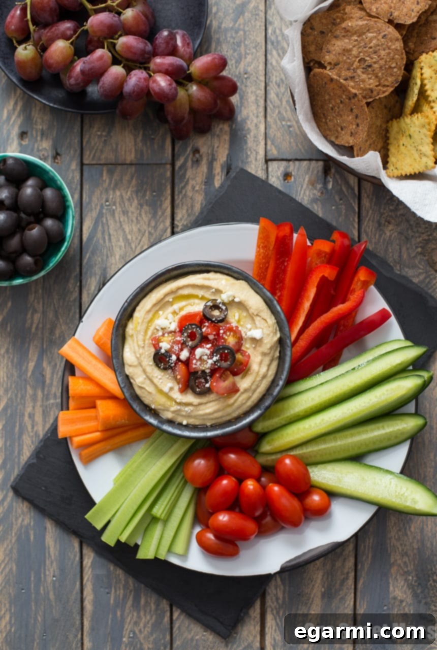Vibrant Greek Hummus Platter with fresh toppings and dippers