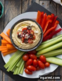 Finished Greek Hummus Platter with fresh toppings and an assortment of dippers