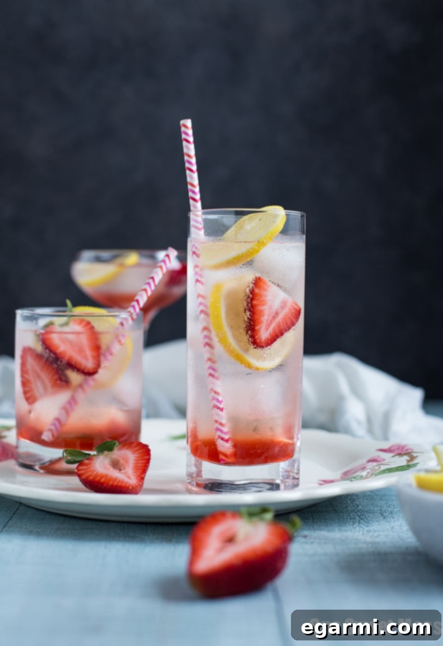 Refreshing Strawberry Lemon Gin Fizz cocktail with fresh strawberries and lemon slices, perfect for summer.