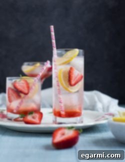 Ingredients for a delicious Strawberry Lemon Gin Fizz on a wooden surface.