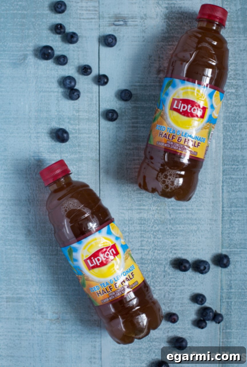 Lipton Sweet Tea Lemonade bottles and fresh fruit on an outdoor table, ready for sangria preparation