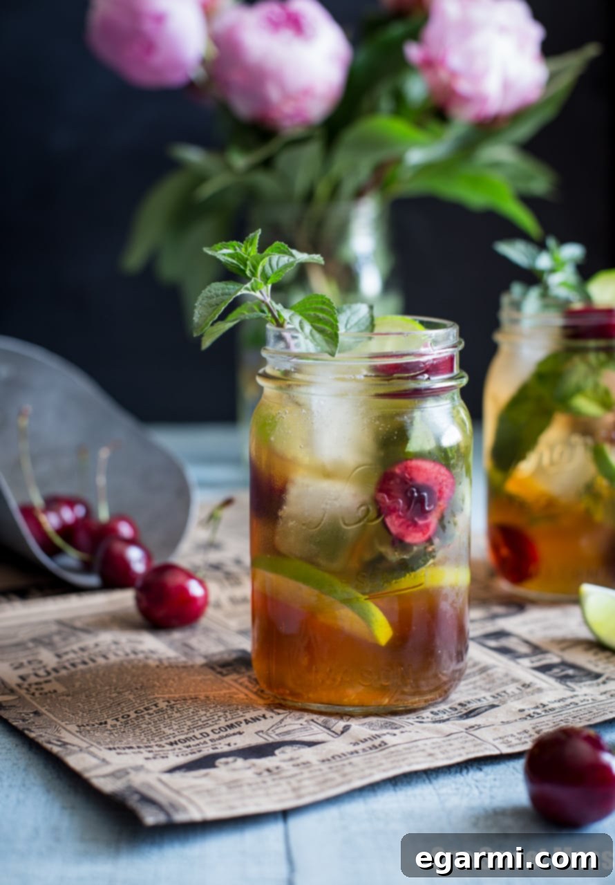 Fresh black cherries being muddled with lime and mint for a cocktail preparation