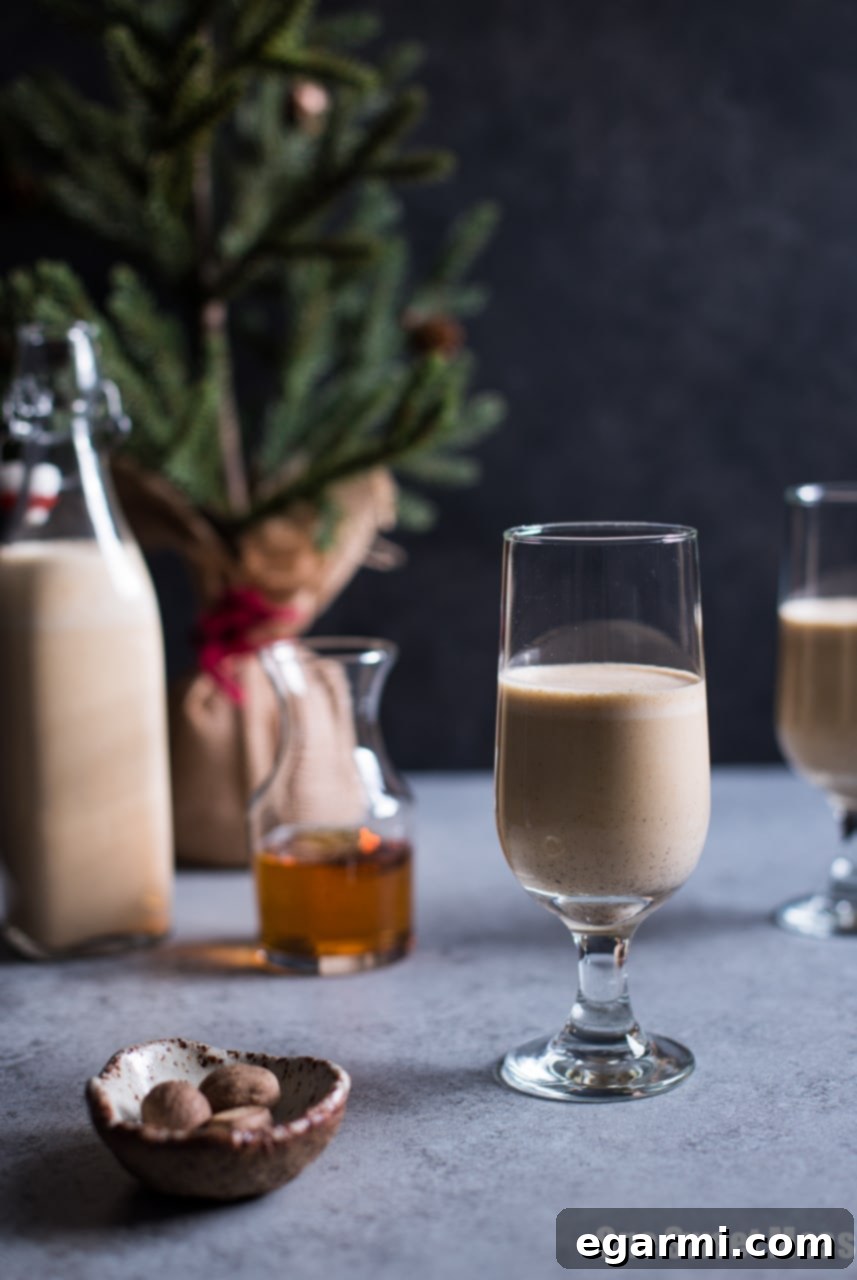Harvest Pumpkin Bourbon Eggnog 4 Elegant glass of Pumpkin Spice Bourbon Eggnog, decorated with cinnamon and dried orange for the festive season