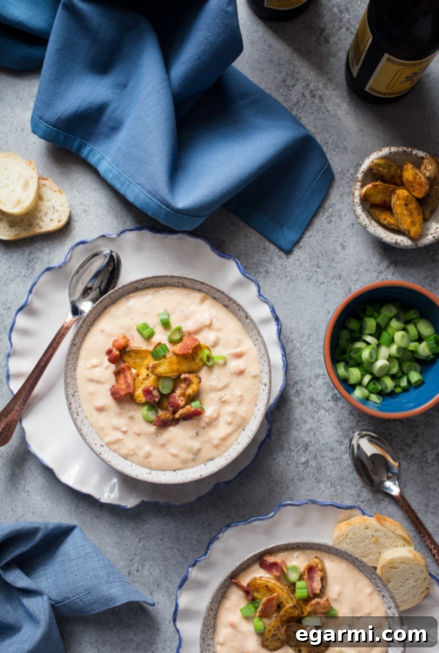 Rich Bacon Beer Cheese Soup topped with crispy potato croutons and fresh scallions