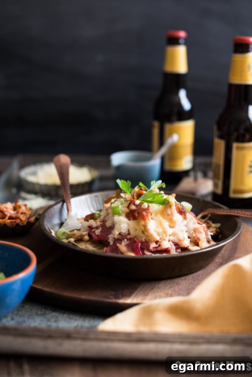 Close-up of Reuben Irish Nachos with melted cheese and fresh toppings.