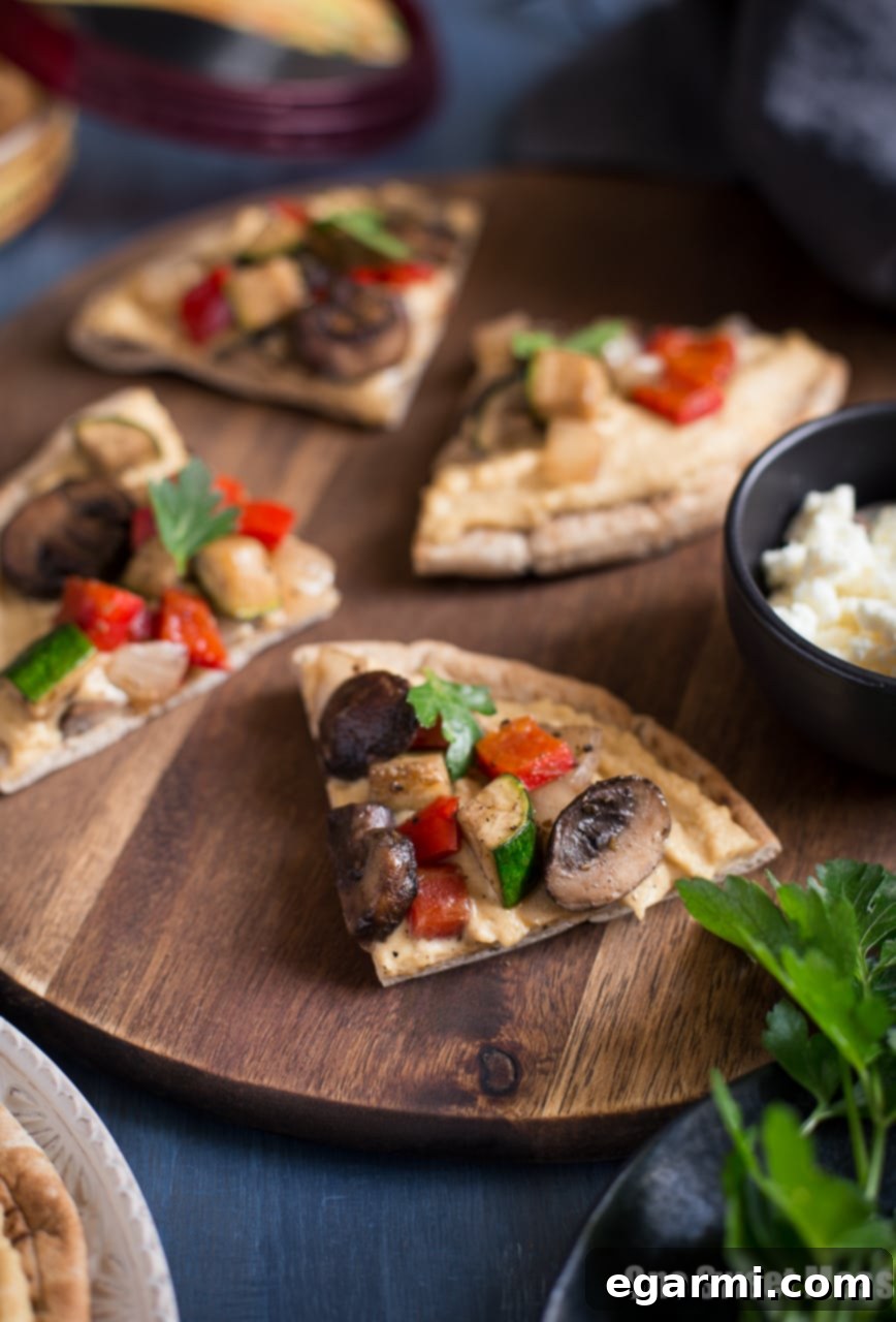 Close-up of Mediterranean Grilled Veggie Pita Pizza with feta and fresh parsley.