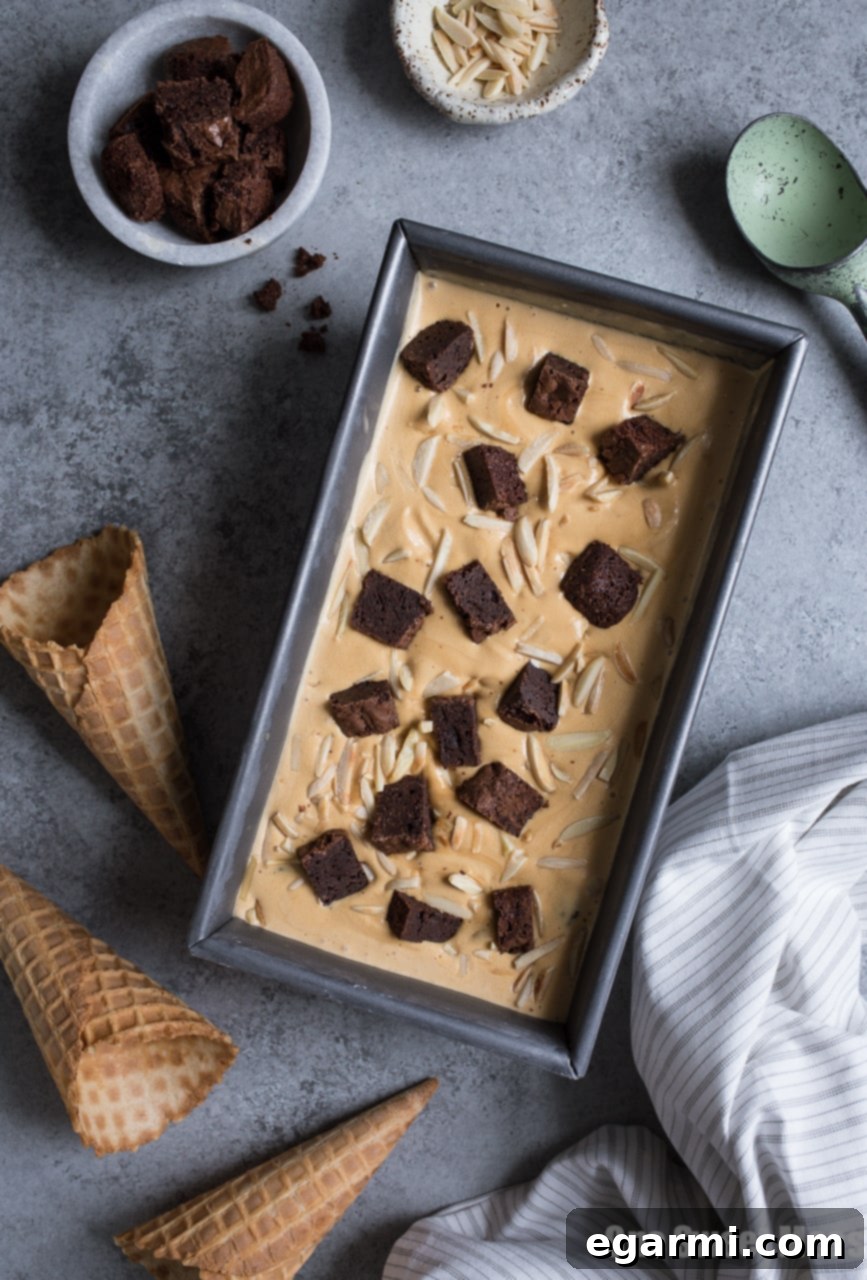 Scoop of Salted Caramel Bourbon Fudge Brownie Ice Cream with visible chunks of brownie and almonds