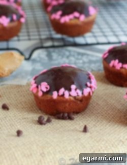 A basket of freshly baked chocolate glazed peanut butter banana muffins.