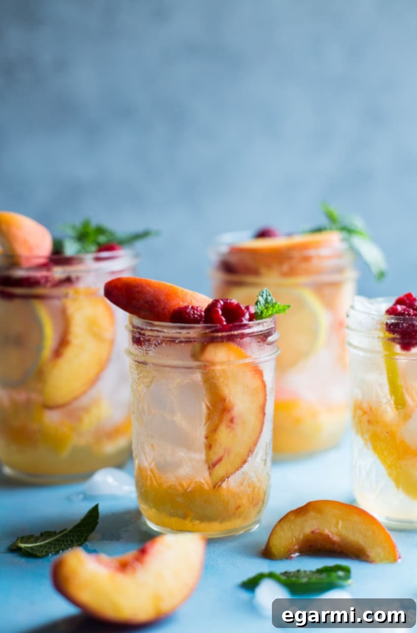 Freshly prepared ingredients for a Peach Crush Cocktail: ripe peaches, lemon, quality peach vodka, and peach liqueur