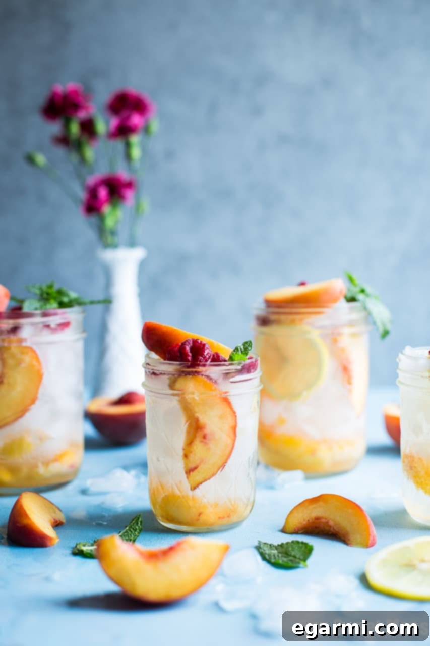 A bartender mixing a Fresh Peach Crush Cocktail in a shaker with muddled fresh peaches and spirits