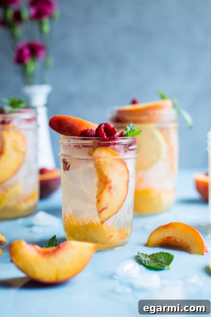Delicious Fresh Peach Crush Cocktail served in a stylish glass with a peach slice and fresh mint garnish