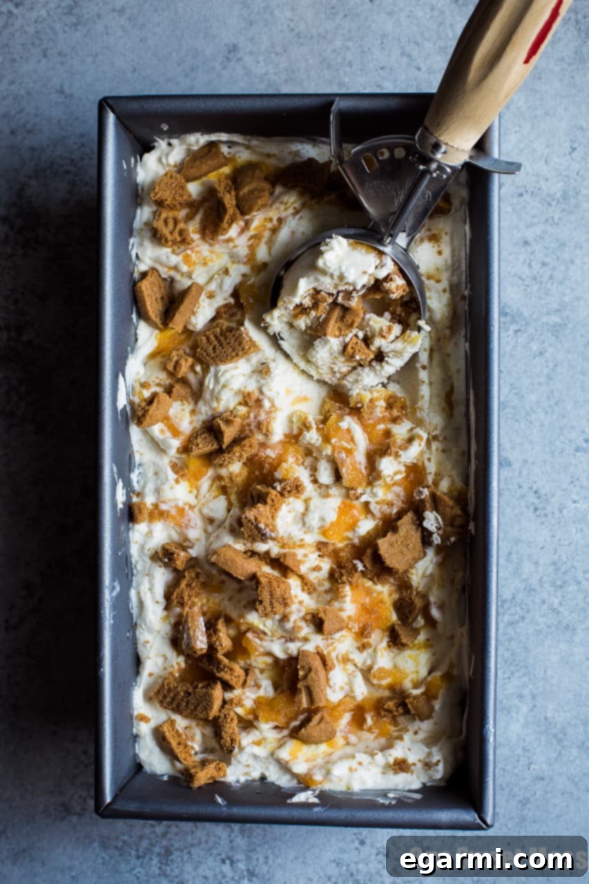 Creamy No-Churn Peach Cobbler Ice Cream with layers of peach compote and cookie crumbles.