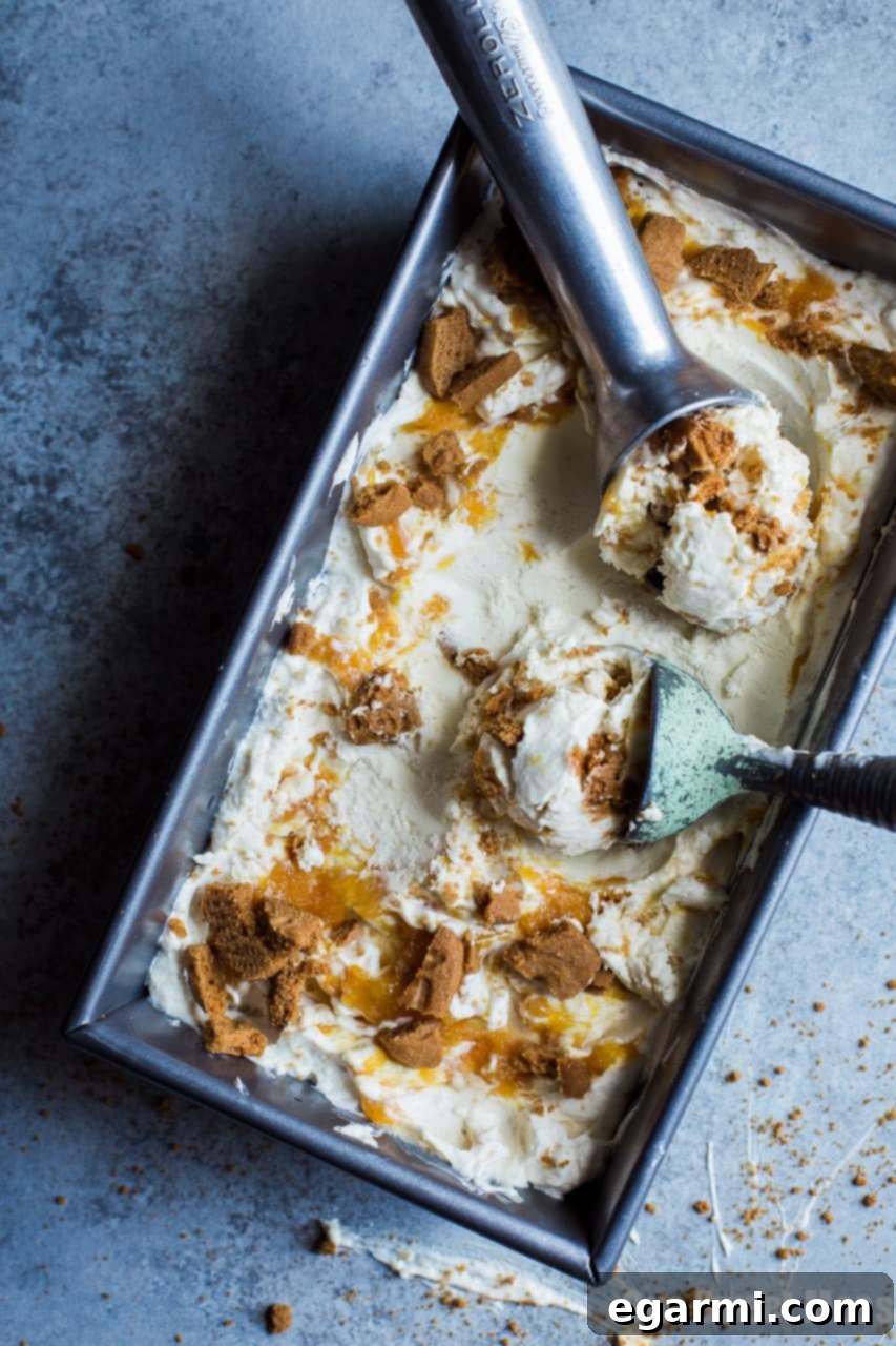 No-Churn Peach Cobbler Ice Cream layered in a loaf pan with compote and cookies.