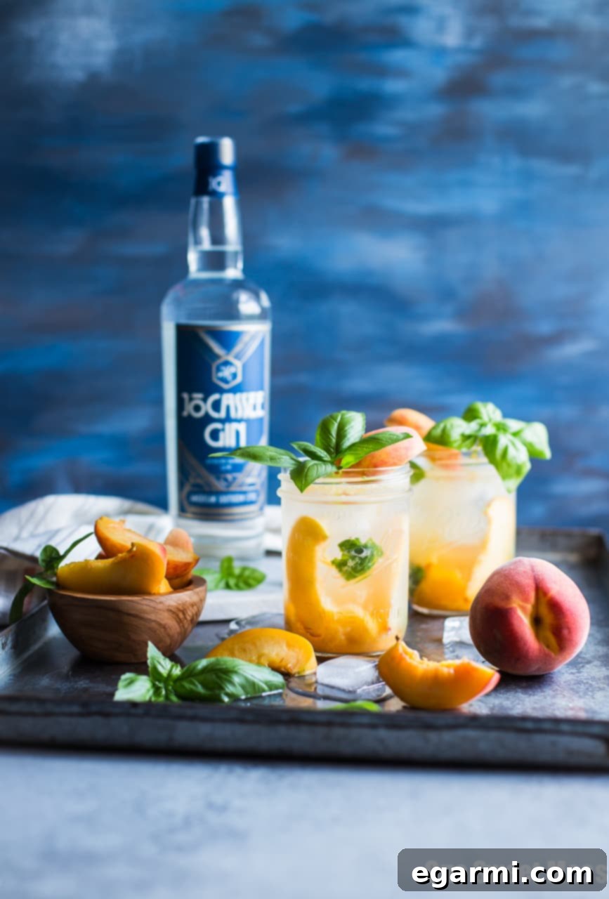 Vibrant Peach Basil Gin Fizz cocktail in a stylish glass, garnished with fresh basil and peach slices