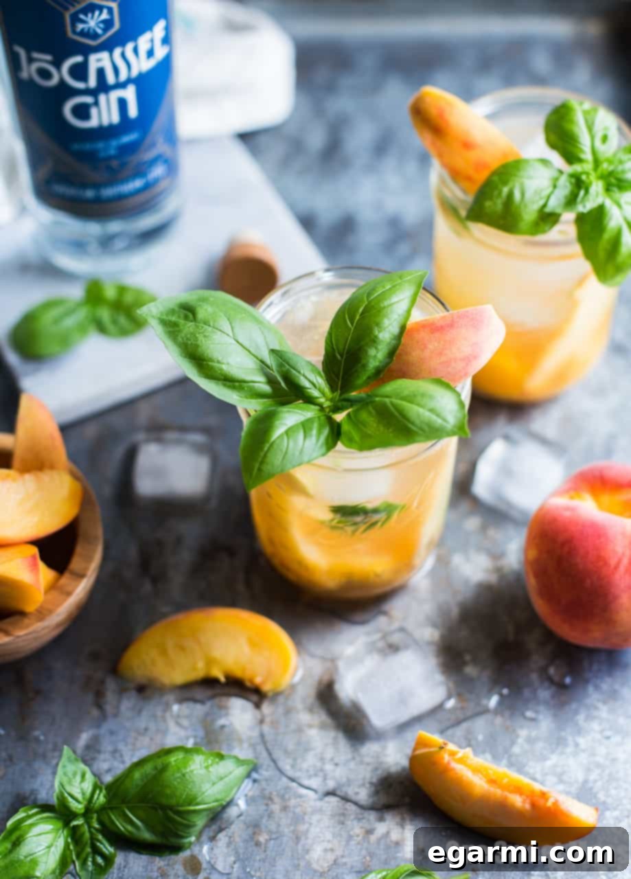 Side view of a Peach Basil Gin Fizz cocktail, highlighting its fresh ingredients and bubbly texture