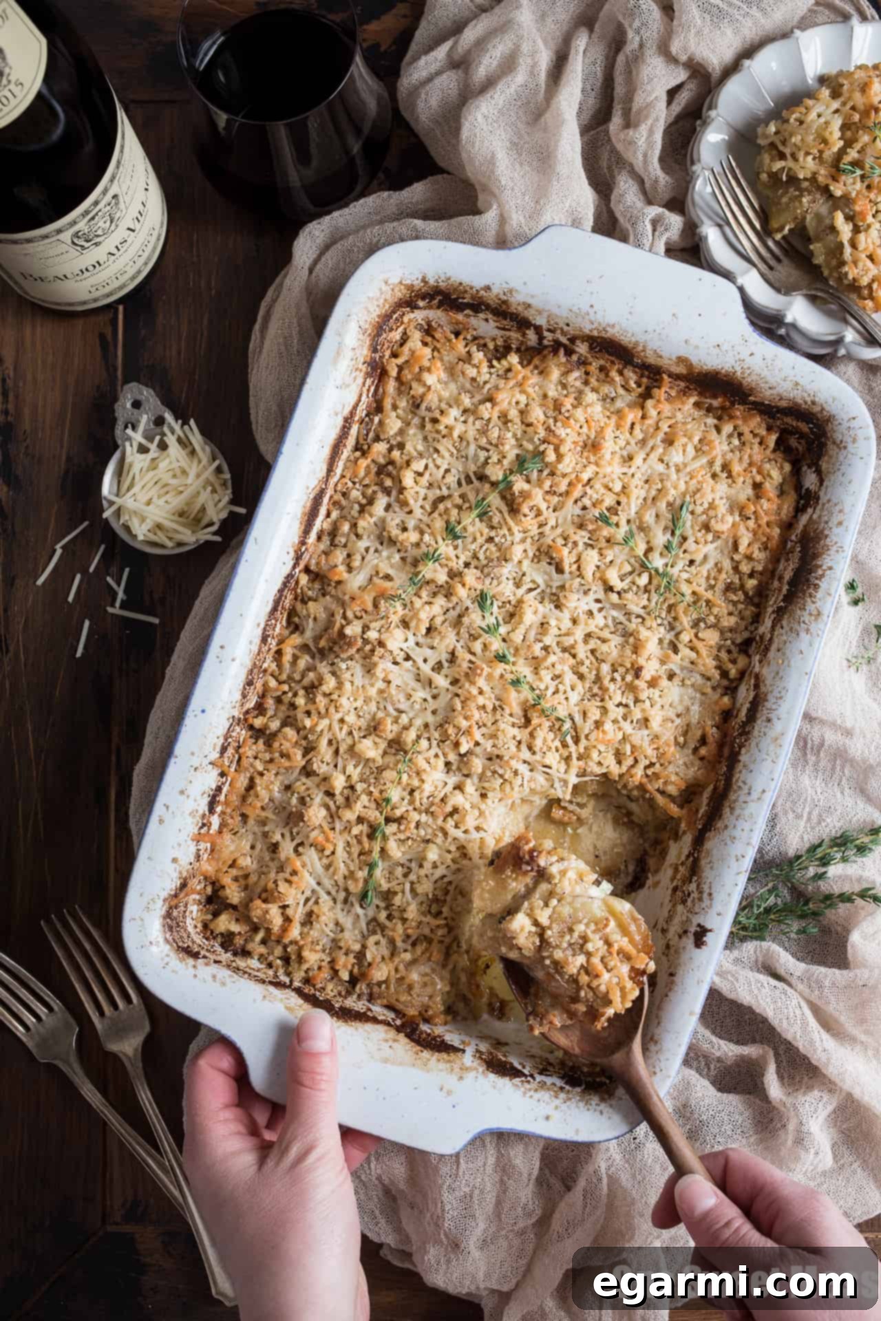 A large baking dish filled with Potato Leek Gratin, freshly baked with a golden crust, ready to be portioned and served.