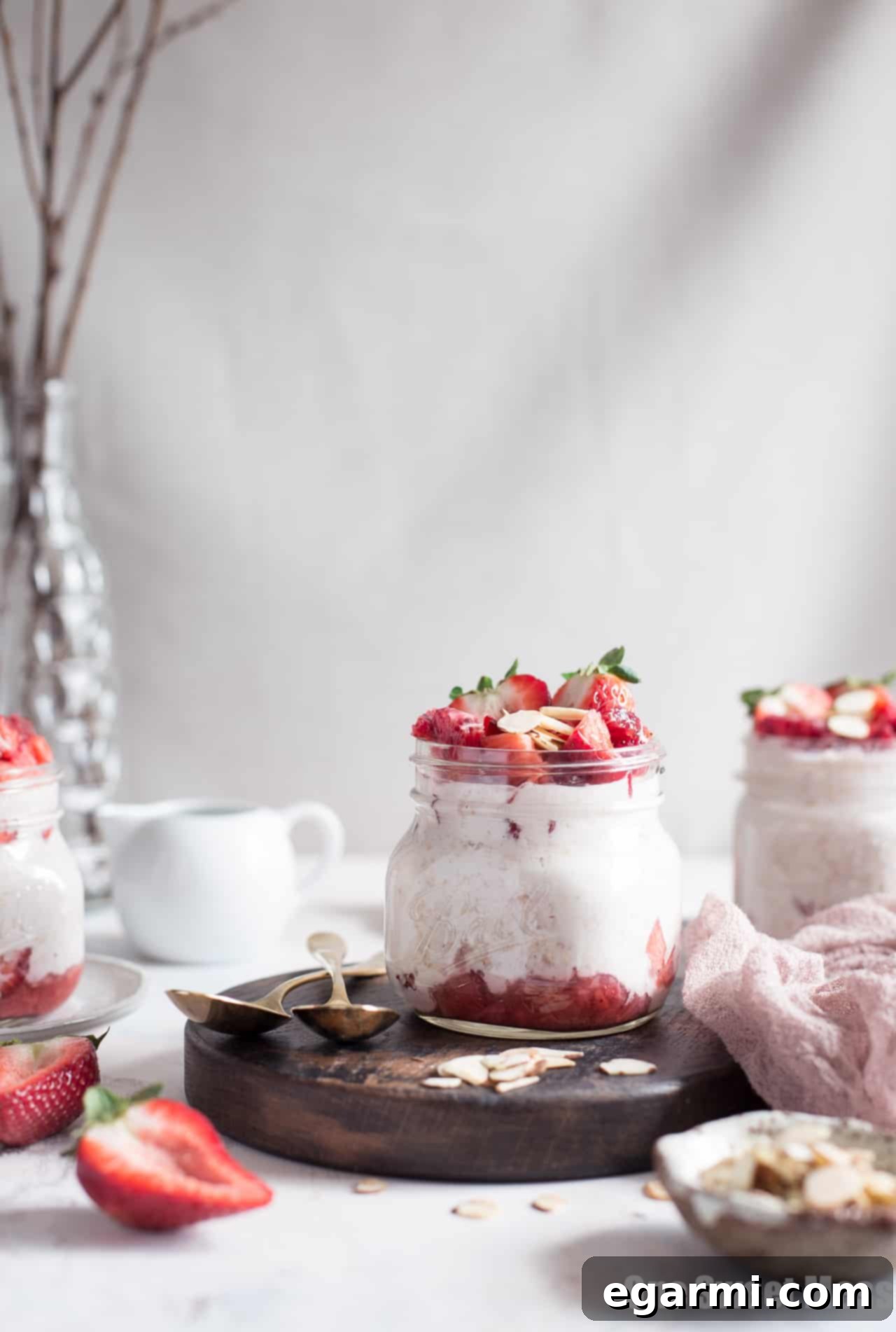 Finished Strawberries and Cream Overnight Oatmeal in a jar, topped with almonds and fresh fruit.