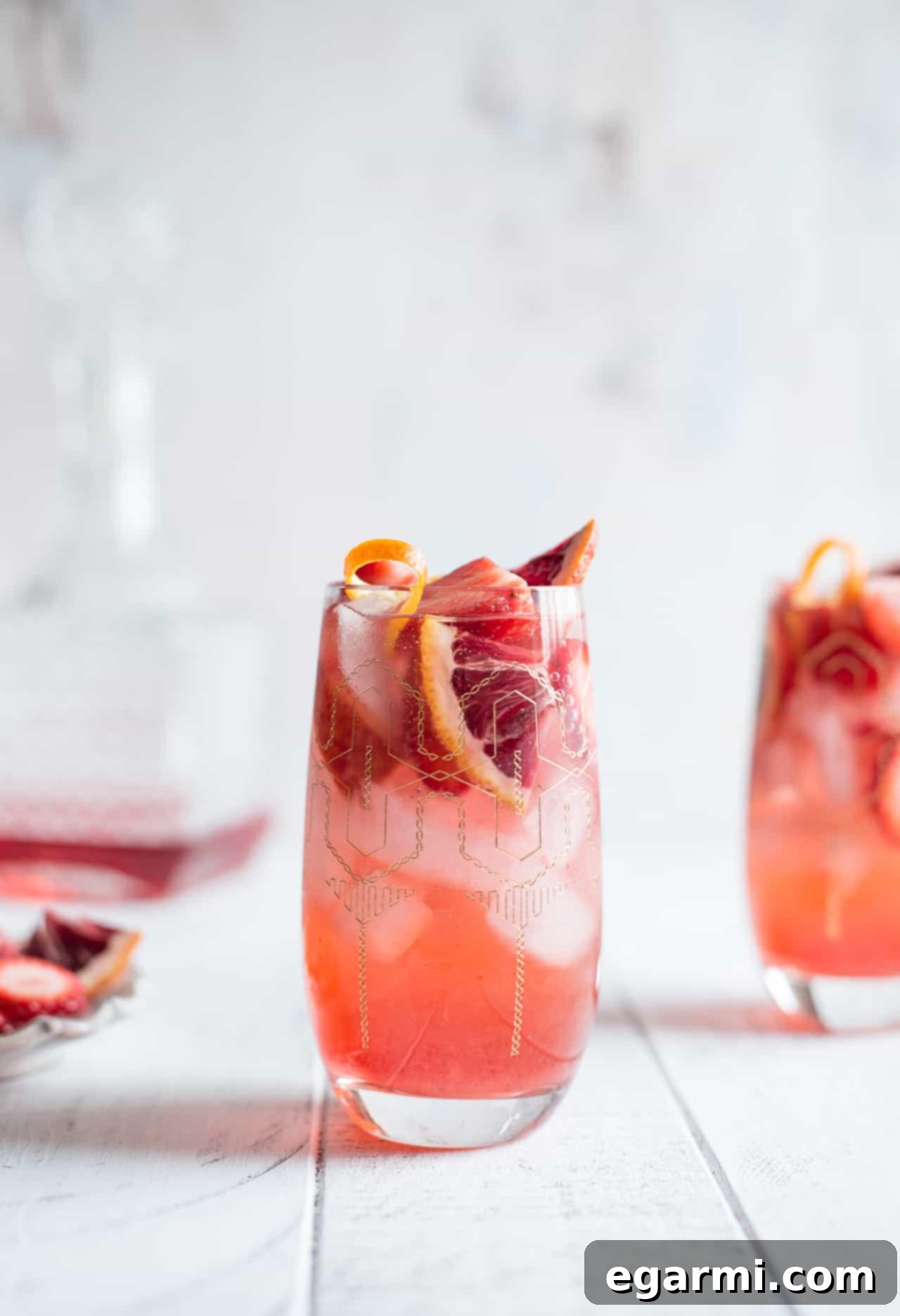 Strawberry Campari Gin Spritz with fresh strawberries and orange peel garnish