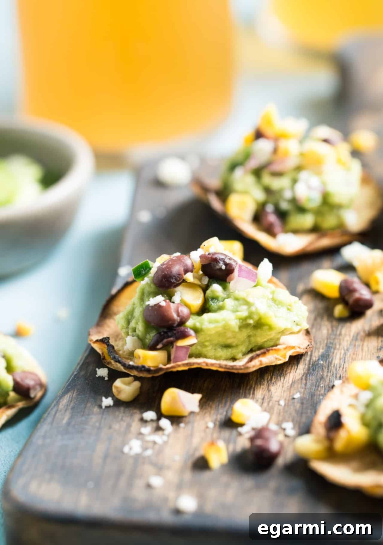 Various Grilled Corn Salsa & Guacamole Tostadas arranged on a platter, showcasing the vibrant colors and fresh ingredients. Ideal for parties.
