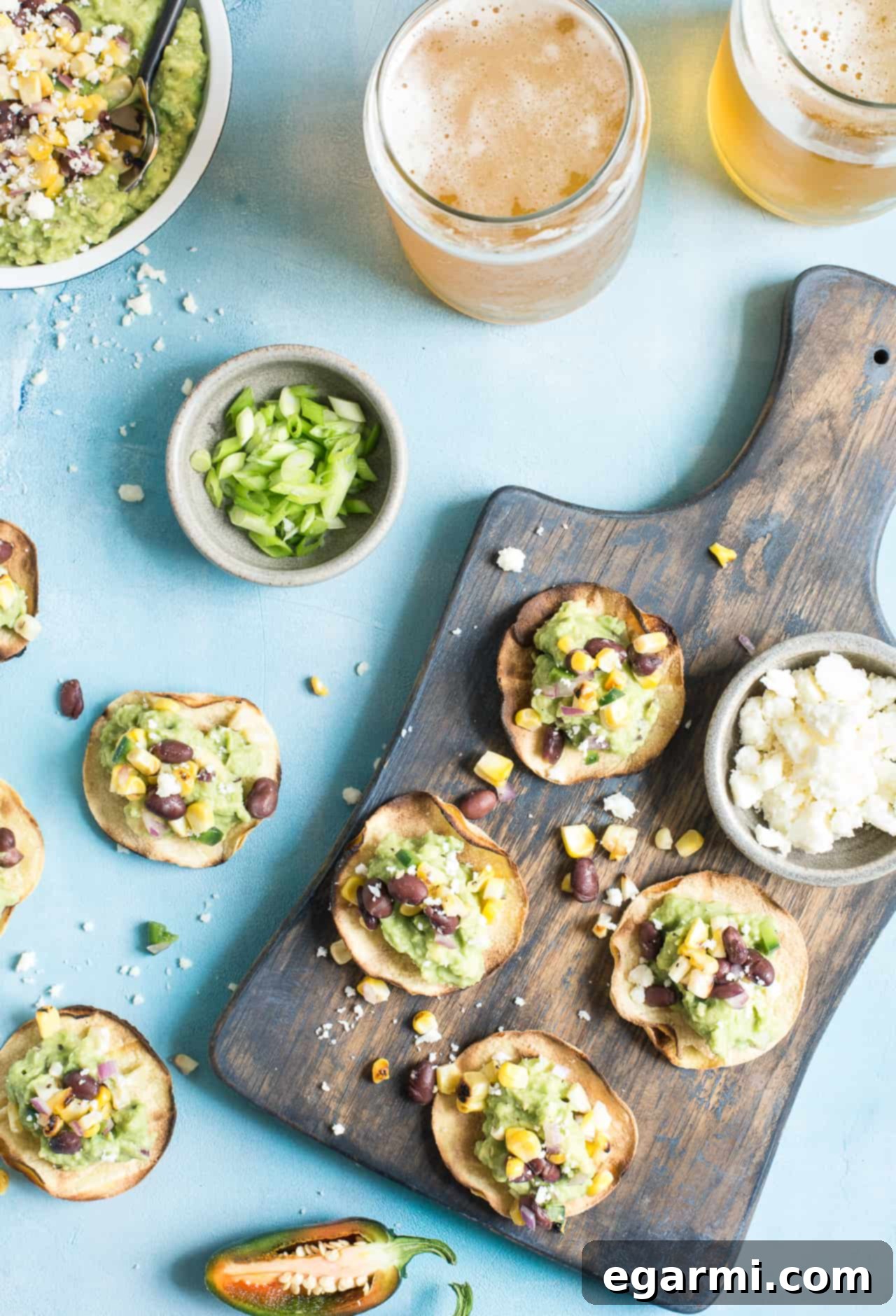 Platter of delicious Grilled Corn Salsa & Guacamole Tostadas, garnished with fresh cilantro and Cotija cheese. Perfect for sharing.