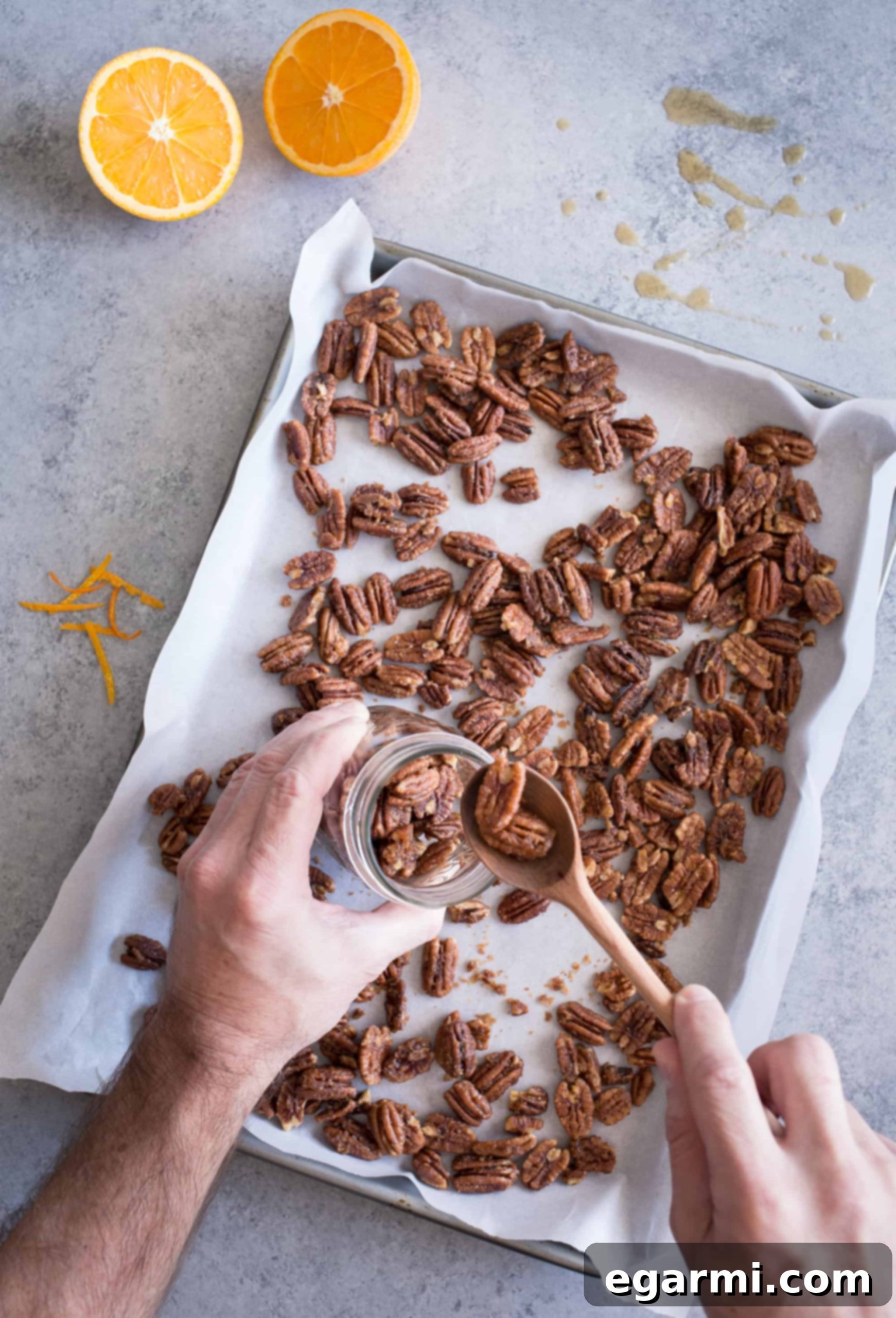 A bowl of Maple-Orange Roasted Pecans with an orange zester and fresh orange peel beside it.