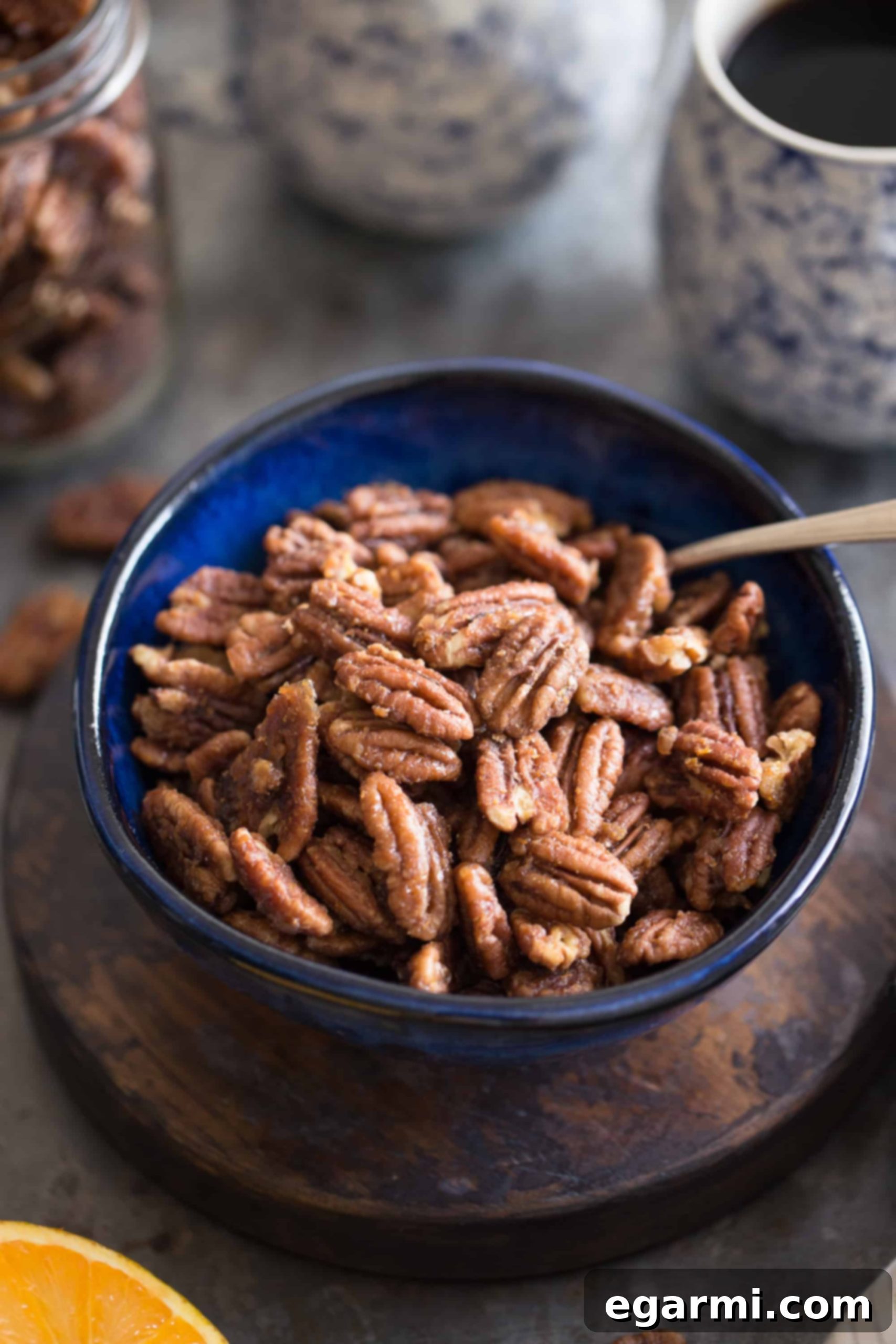 A baking sheet filled with evenly spread Maple-Orange Roasted Pecans, fresh out of the oven.