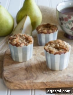 A collection of freshly baked Pear Cinnamon Muffins with a golden streusel topping, presented invitingly.