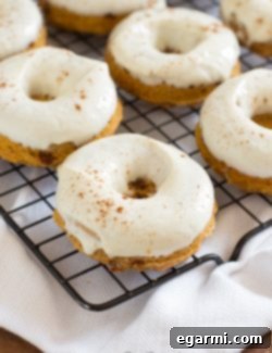 A freshly baked Skinny Pumpkin Cinnamon Chip Donut with Maple Cream Cheese Glaze