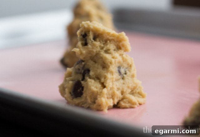 Close-up of chocolate chip cookie dough being mixed in a bowl.