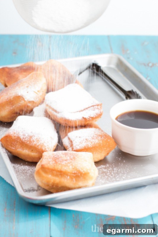 Freshly fried Buttermilk Beignets resting on a cooling rack