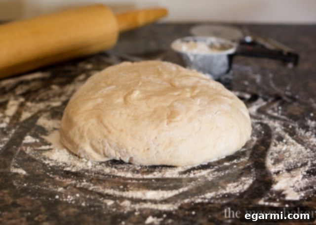 Soft, risen Buttermilk Beignet dough in a bowl, covered for proofing