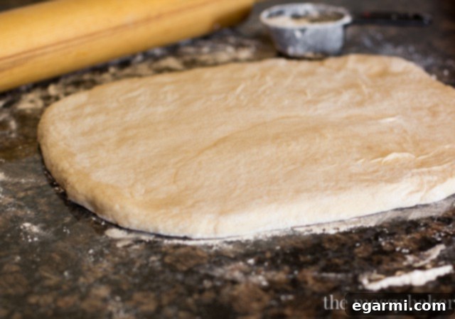 Rolling out Buttermilk Beignet dough on a floured surface to an even thickness