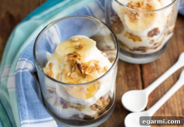 Horizontal shot of two Banana Bread Parfaits, one with a spoon, highlighting their rich texture and presentation as a healthy breakfast or snack