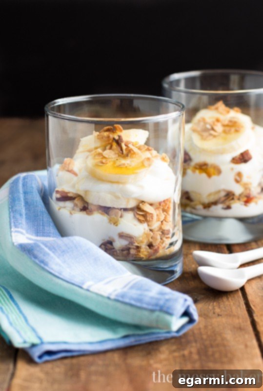 Detailed shot of Banana Bread Parfait ingredients: Greek yogurt, banana maple granola, sliced bananas, and honey, ready for assembly
