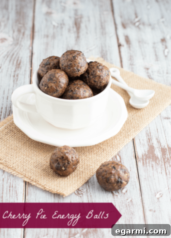 Close-up of a Cherry Pie Energy Ball on a rustic background, highlighting its texture and deliciousness.