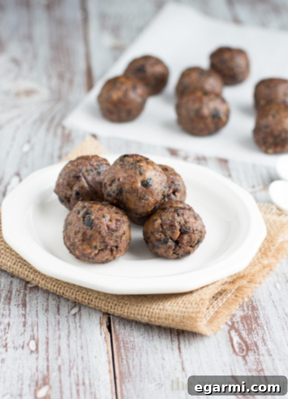 Several Cherry Pie Energy Balls artfully arranged on a wooden board, ready to be enjoyed as a healthy snack.