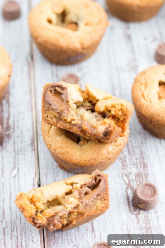 Hand holding a Butterscotch Chocolate Caramel Cookie Cup, highlighting its perfect form and inviting gooey center