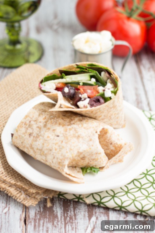 Ingredients for a Greek Salad Wrap laid out on a cutting board