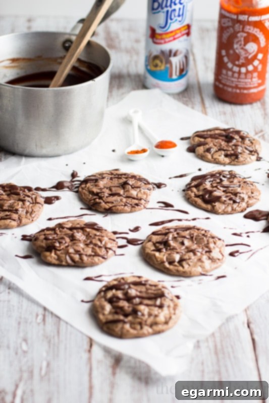 Rich Double Chocolate Brownie Cookies topped with a vibrant Sriracha Ganache drizzle, showcasing a perfect balance of sweet and spicy flavors for an adventurous palate.