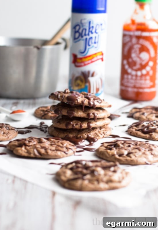 Decadent Double Chocolate Brownie Cookies with a generous drizzle of Sriracha Ganache, showcasing their rich color and inviting texture.
