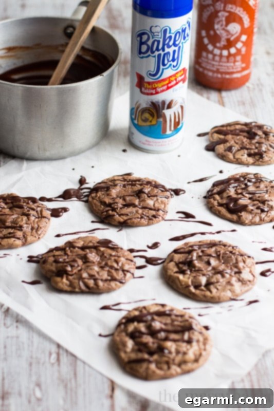 A beautifully arranged plate of Double Chocolate Brownie Cookies generously drizzled with spicy Sriracha Ganache, ready to serve.