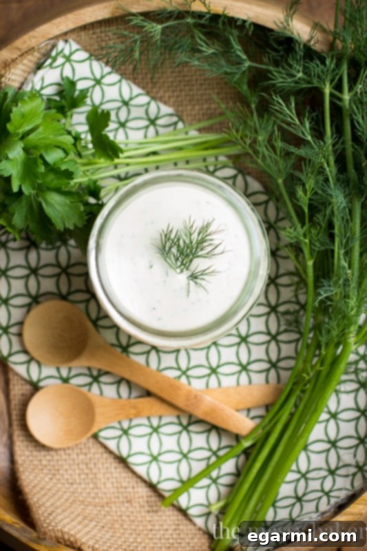 Jar of Homemade Buttermilk Ranch Dressing with Fresh Herbs and a Wooden Spoon