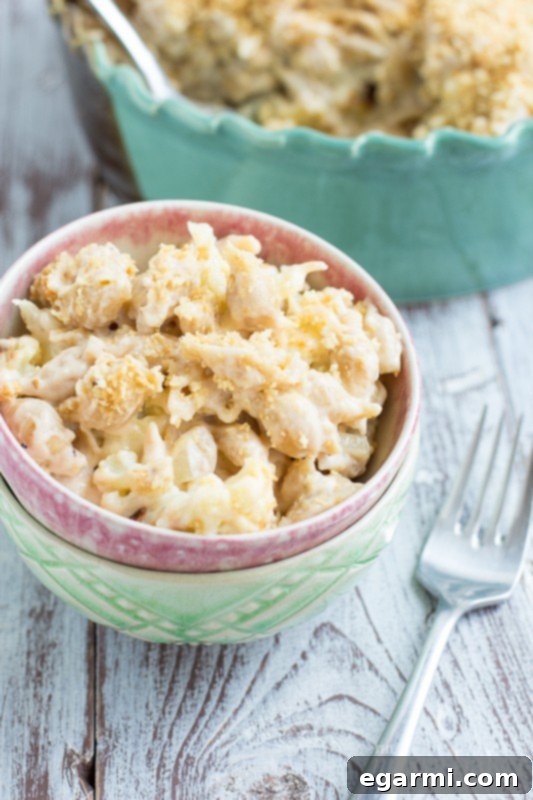 Mixing whole grain pasta and roasted cauliflower into cheese sauce