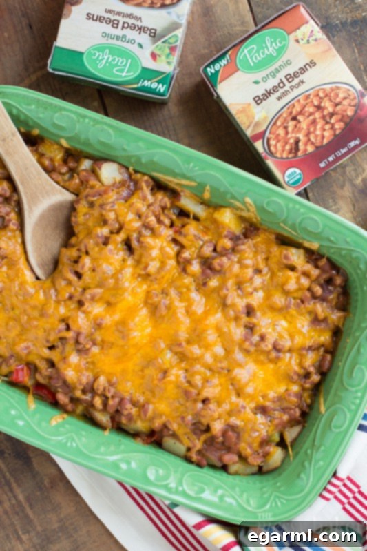 Hearty Loaded Potato and Baked Bean Bake 2 Loaded Baked Potato & Baked Bean Casserole featuring crispy potatoes, savory beans, and melted cheese, perfect for a cozy meal