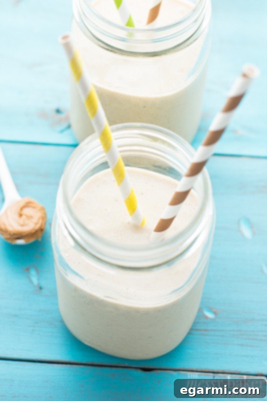 Energizing Peanut Butter Banana Oat Smoothie 4 A refreshing glass of Peanut Butter Banana Oat Smoothie with a straw.